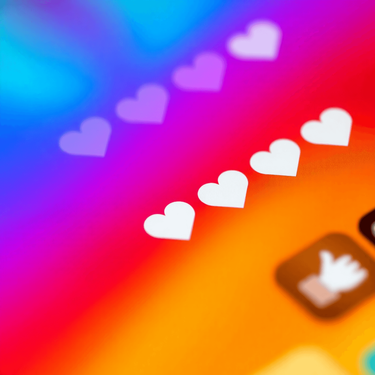 Nahaufnahme eines Smartphone-Bildschirms mit einem Social-Media-Reel, vielen Likes und Herz-Icons vor einem bunten, lebendigen Hintergrund.